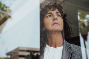 Woman looking out the window with serious expression
