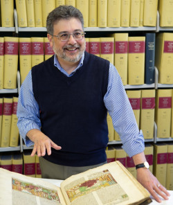 Christopher M. Bellitto in a library with an open book in front of him