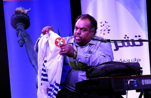 Daryl Davis holding up KKK robes at Blues and Rock for Humanity in November 2017.