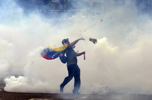 A demonstrator throws stones at riot police during an anti-government protest in eastern Caracas, Venezuela, on February 27th, 2014.