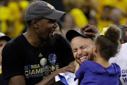Kevin Durant (left) and Stephen Curry of the Golden State Warriors celebrate with Curry’s daughter after winning the 2017 NBA Finals.