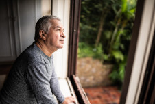 Man looking out the window with serious expression