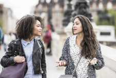 Two friends walking and talking outside