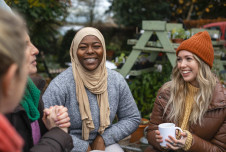 Group of four diverse friends sitting together talking