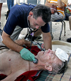 A doctor tends to a man hurt by Hurricane Katrina.