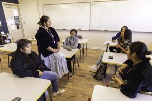 A classroom teacher sitting in a circle talking with her students