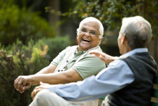 Two older men outdoors talking and laughing