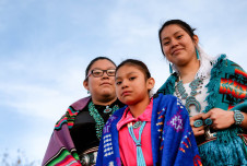 Three Indigenous young women in traditional dress
