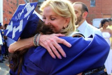 Elaine Wynn, right, chair of the board of directors for Communities In Schools, congratulates Talitha Halley. In the years since Halley fled Katrina, the organization helped her realize her goal of graduating from Howard University. 