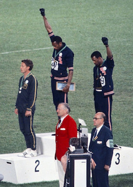 American sprinters Tommie Smith (center) and John Carlos raise black-power fists at the 1968 Mexican Olympic games.