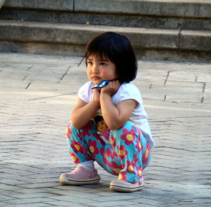 Small child squatting on floor