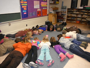 Students in the Kindness Curriculum work on “mindful movement,” getting ready for cobra pose.