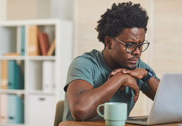 Young black man looking at laptop screen