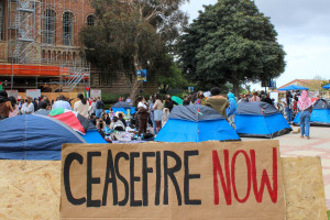 An encampment at UCLA with numerous students and a sign saying 