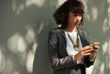 a woman in a suit using her smartphone outdoors