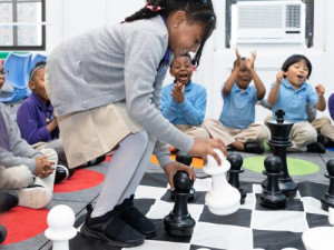 Children at Zeta Charter School in the Bronx are playing a large chess game