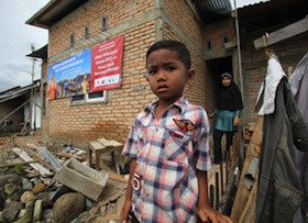 A boy stands outside his home following the devastating 2009  earthquake in Padang, Indonesia.